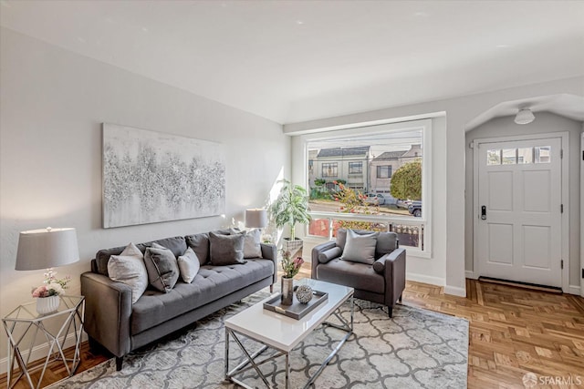 living room featuring arched walkways and baseboards