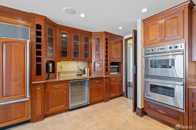765 Market St Unit 28D, San Francisco, CA 94103 - kitchen featuring wine cooler, stainless steel appliances, light stone countertops, glass insert cabinets, and brown cabinetry