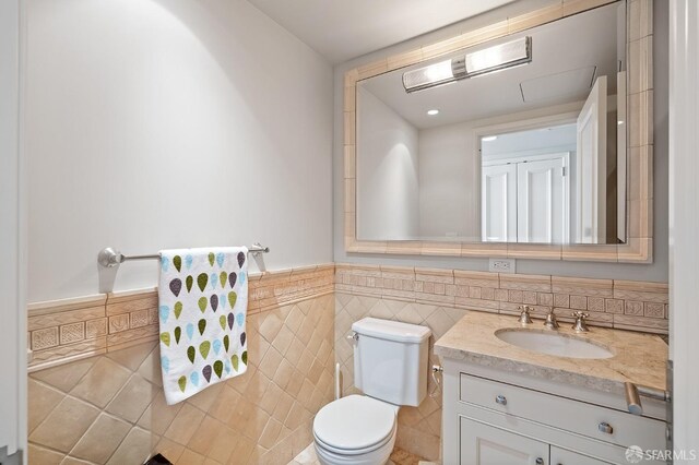 765 Market St Unit 28D, San Francisco, CA 94103 - bathroom featuring toilet, tile walls, a wainscoted wall, and vanity