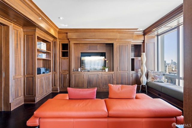 cinema with dark wood-type flooring, built in shelves, and ornamental molding