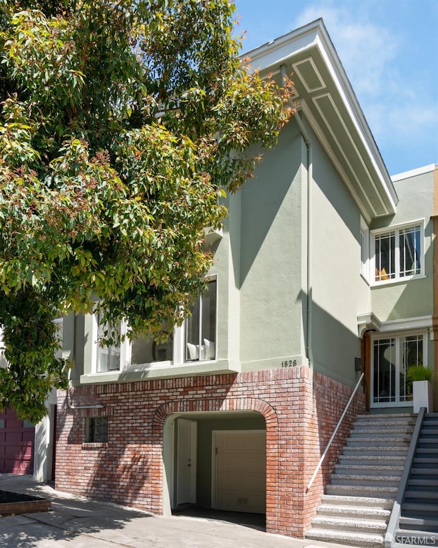 1828 Grove St, San Francisco, CA 94117 - view of front of home with a garage, brick siding, stucco siding, and driveway