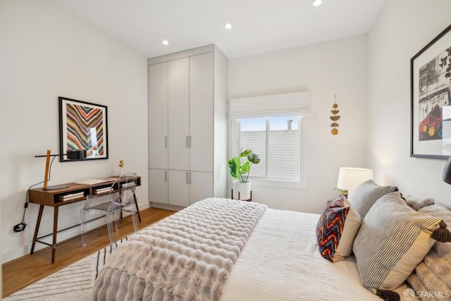 bedroom featuring recessed lighting, a closet, baseboards, and wood finished floors