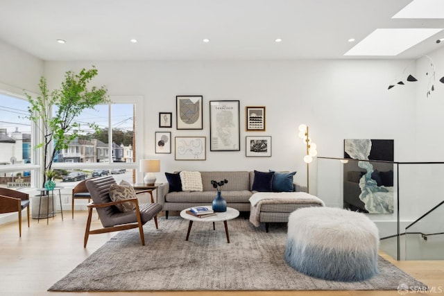 living room with a skylight, wood finished floors, and recessed lighting