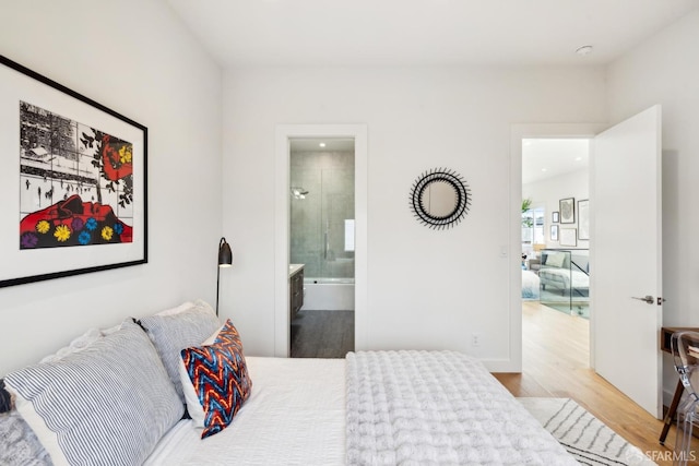 bedroom with ensuite bath and wood finished floors