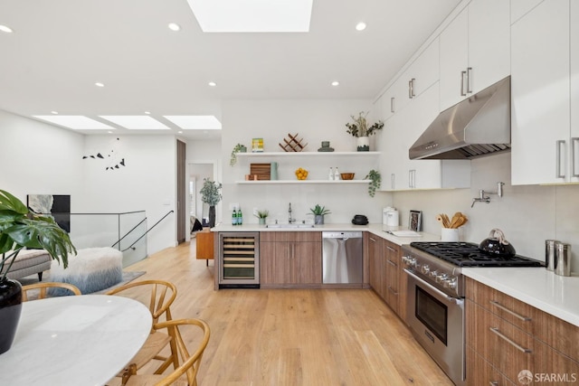 kitchen featuring under cabinet range hood, beverage cooler, a skylight, appliances with stainless steel finishes, and open shelves