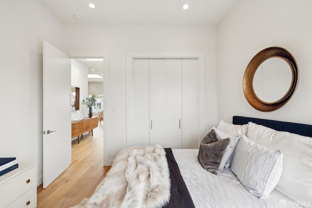 bedroom with light wood finished floors, a closet, and recessed lighting