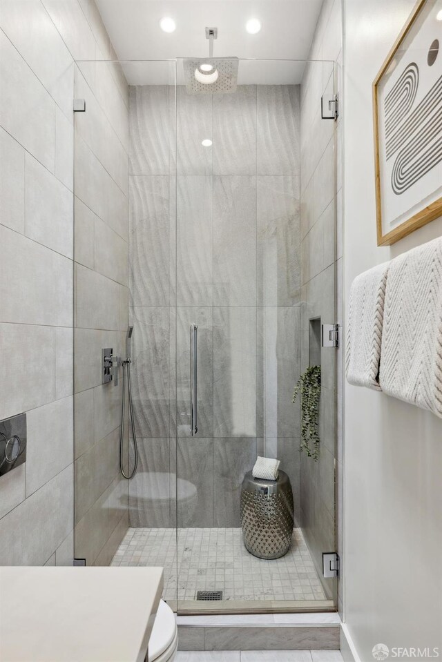 bathroom featuring toilet and a shower stall