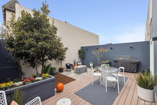 wooden deck with outdoor dining space and area for grilling