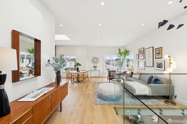 living area with light wood-style floors, recessed lighting, and a healthy amount of sunlight