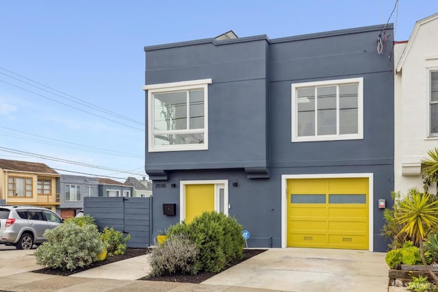 view of front of property featuring a garage, concrete driveway, and stucco siding