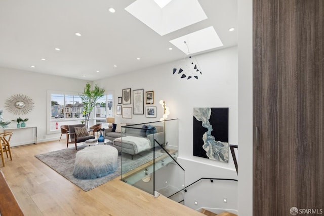 living room featuring a skylight, recessed lighting, and wood finished floors