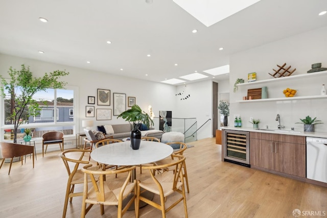 dining space with light wood-style floors, wine cooler, and recessed lighting