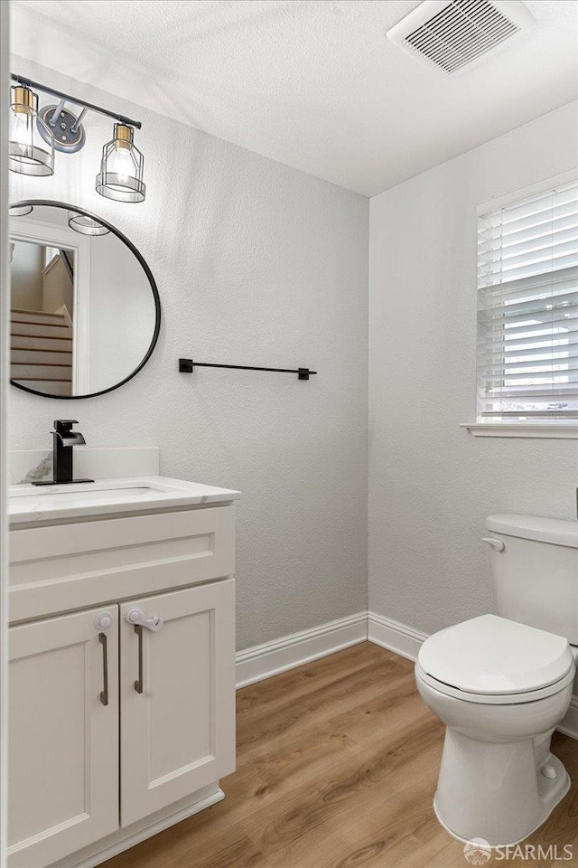 67 Greystone Pl, Pittsburg, CA 94565 - bathroom with toilet, vanity, baseboards, and wood finished floors
