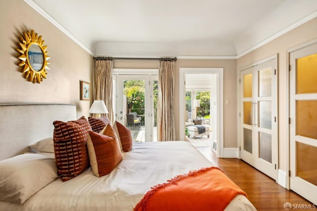 bedroom with access to outside and wood finished floors
