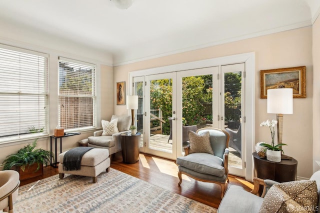 sitting room featuring ornamental molding, wood finished floors, french doors, and a healthy amount of sunlight