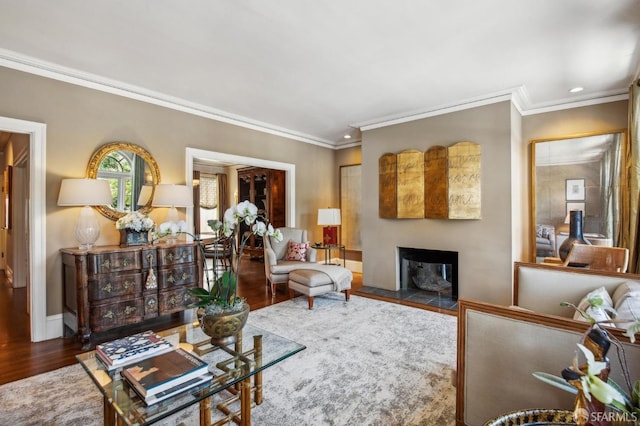 living area with wood finished floors, a fireplace, baseboards, ornamental molding, and recessed lighting
