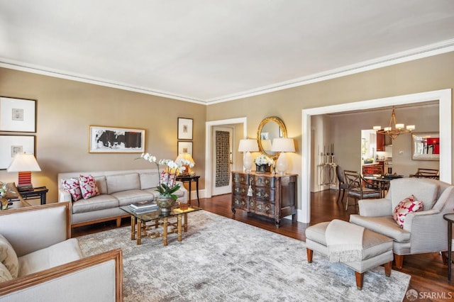 living room with crown molding, wood finished floors, baseboards, and a notable chandelier