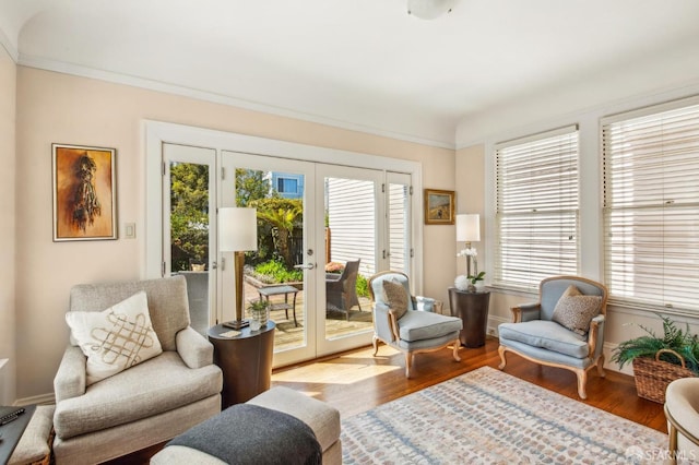 sitting room featuring crown molding, wood finished floors, french doors, and baseboards