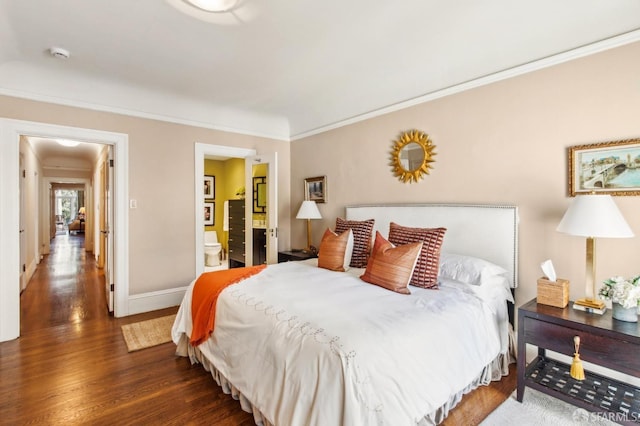 bedroom with ensuite bathroom, wood finished floors, baseboards, and ornamental molding