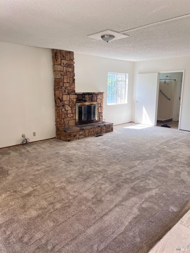 unfurnished living room with a fireplace, a textured ceiling, and carpet floors