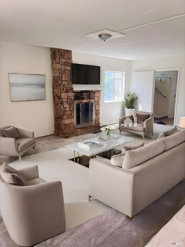 living room with a textured ceiling and a fireplace