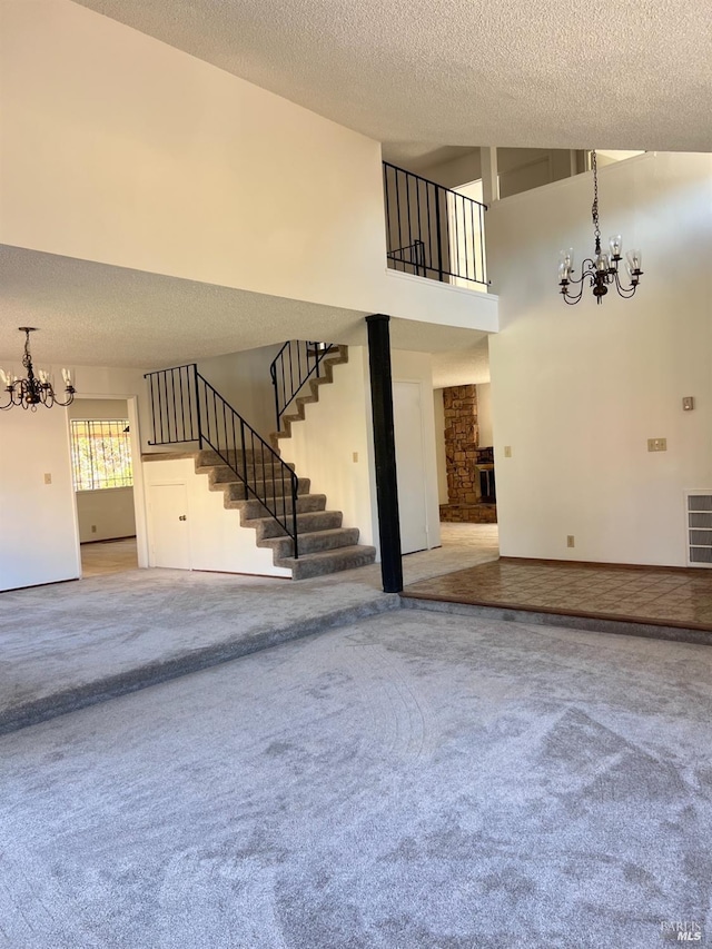 unfurnished living room featuring a fireplace, carpet, a high ceiling, and a textured ceiling