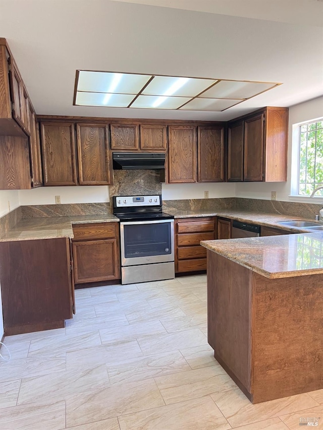 kitchen featuring kitchen peninsula, sink, dark stone counters, and appliances with stainless steel finishes