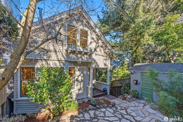 back of property with an outbuilding and a patio