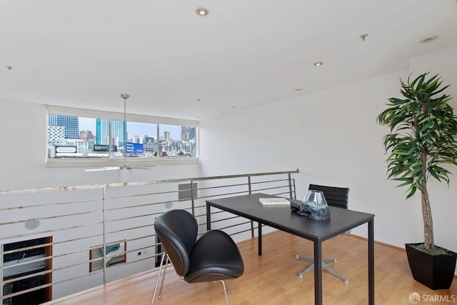 home office with a view of city, wood finished floors, and recessed lighting