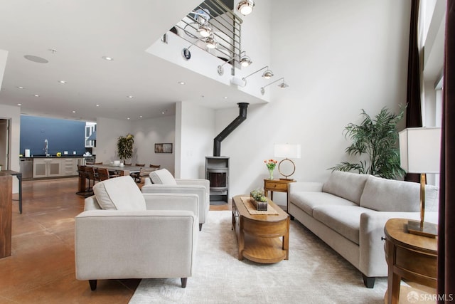 living area with recessed lighting, a wood stove, and concrete floors