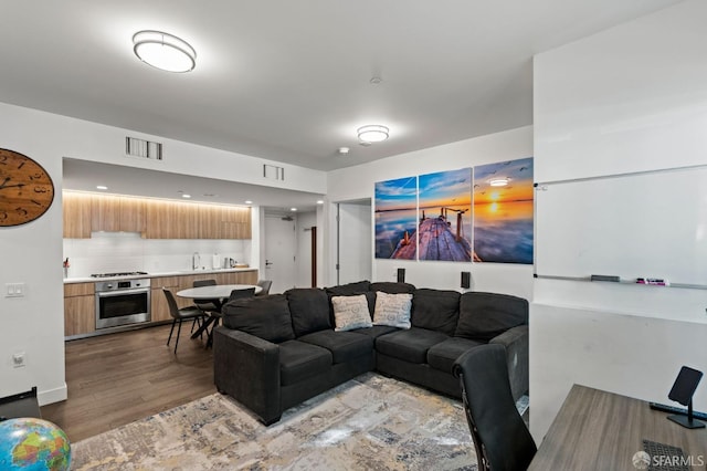 living area featuring visible vents and light wood-style floors