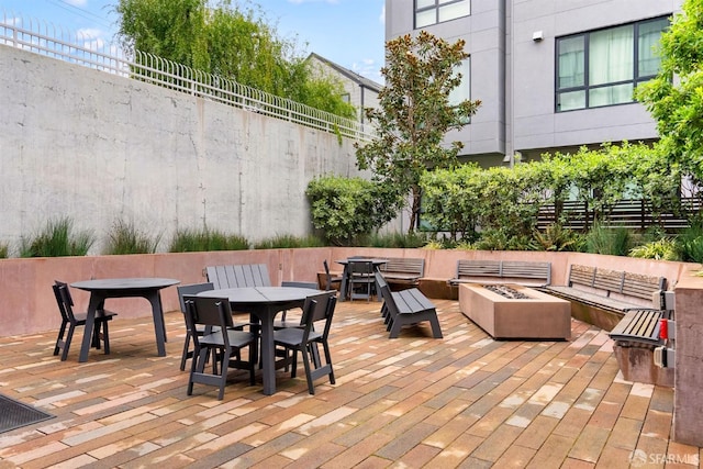 view of patio / terrace featuring an outdoor fire pit, outdoor dining space, and fence