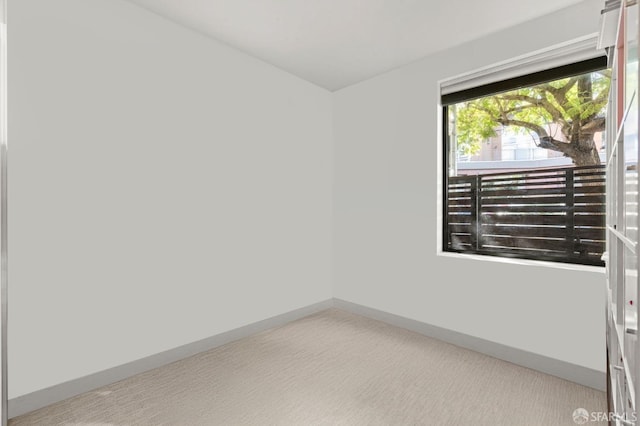 empty room featuring carpet flooring and baseboards