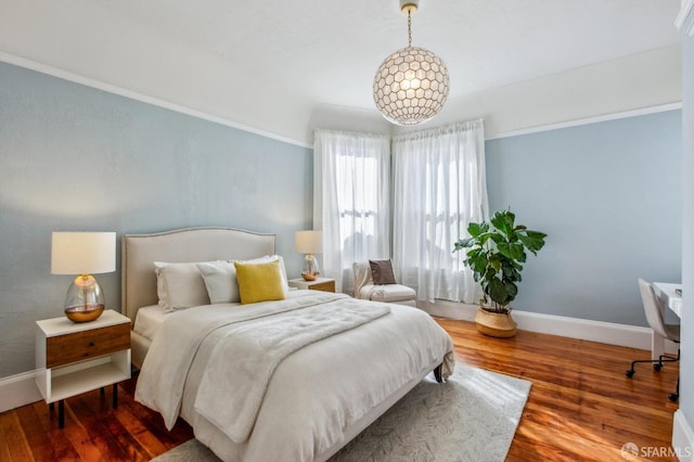 bedroom with a notable chandelier and hardwood / wood-style floors