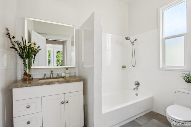 full bathroom with tiled shower / bath combo, tile patterned floors, vanity, tile walls, and toilet