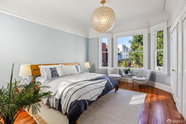 bedroom featuring dark hardwood / wood-style floors and a chandelier