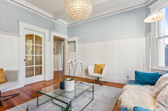 sitting room featuring an inviting chandelier, crown molding, wood-type flooring, and beamed ceiling