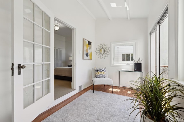 living area featuring wood finished floors and beam ceiling