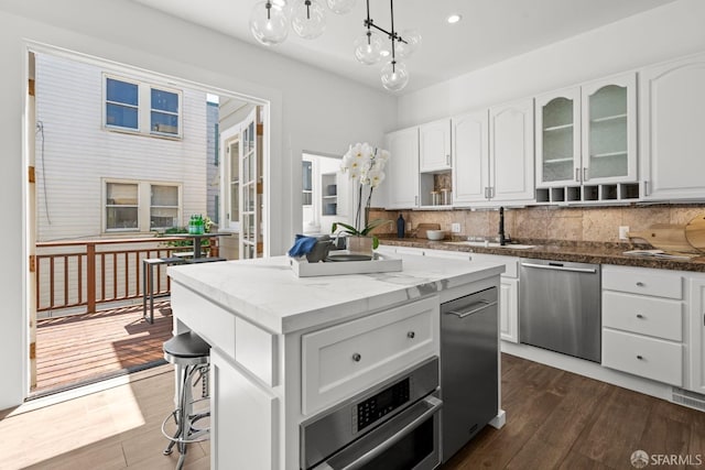 115 Magnolia St, San Francisco, CA 94123 - kitchen with stainless steel dishwasher, a center island, white cabinetry, tasteful backsplash, and a sink