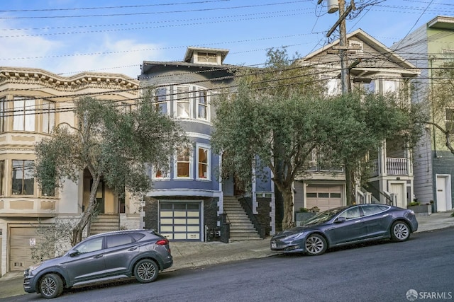 view of front facade with a garage and stairs