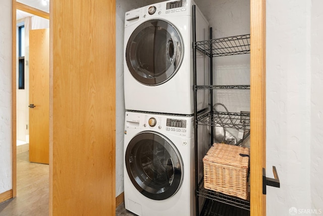 washroom featuring stacked washer and clothes dryer