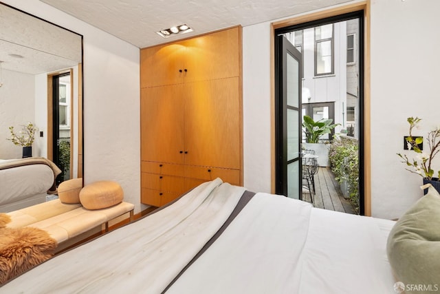 bedroom featuring access to outside and a textured ceiling