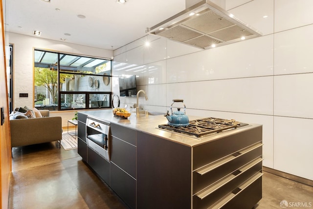 kitchen with white cabinets, exhaust hood, an island with sink, sink, and stainless steel gas cooktop