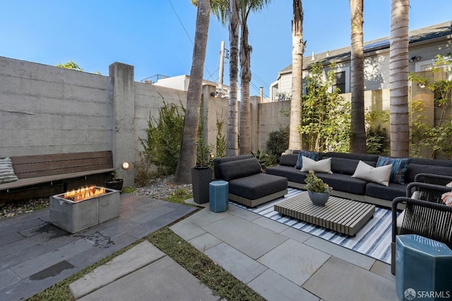 view of patio with an outdoor living space with a fire pit