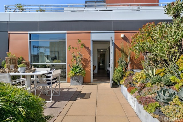 view of exterior entry with outdoor dining space and a patio area