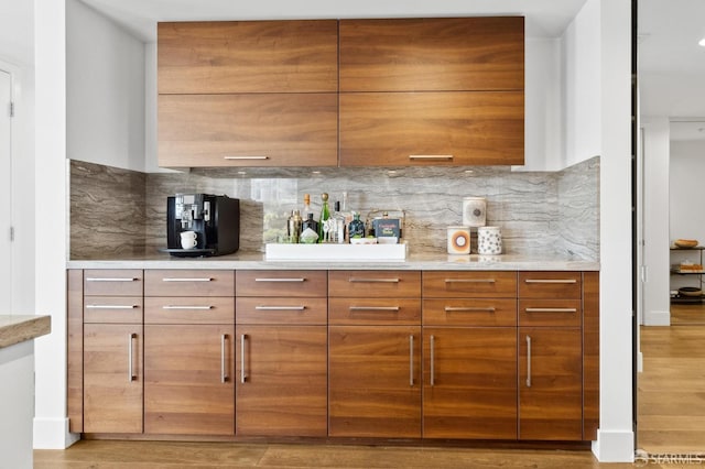 kitchen featuring modern cabinets, brown cabinets, and decorative backsplash