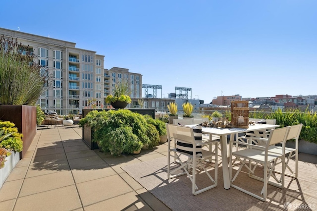 view of patio with outdoor dining space and a city view