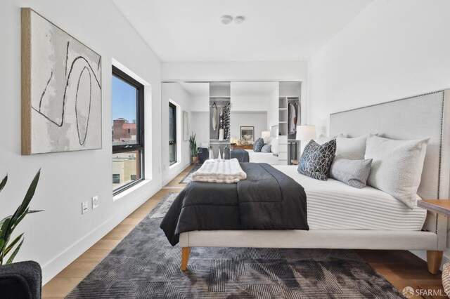 bedroom with a closet, wood finished floors, and baseboards