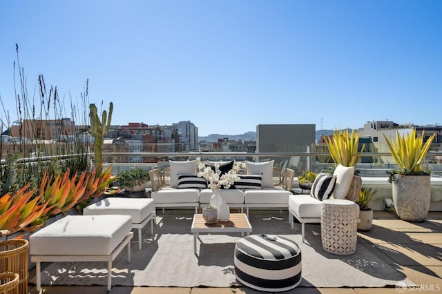 view of patio with a balcony, an outdoor hangout area, and a city view