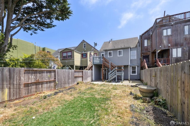 back of property featuring stairs, a fenced backyard, and a residential view